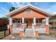 Inviting bungalow-style home featuring a lovely front porch with decorative railings and a well-manicured lawn at 6414 N Central Ave, Tampa, FL 33604