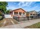Charming single-story home featuring an orange facade, black metal fence, and quaint front porch at 6414 N Central Ave, Tampa, FL 33604
