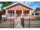 Charming bungalow-style home with a cozy front porch, ornamental iron fence, and well-maintained lawn at 6414 N Central Ave, Tampa, FL 33604