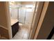 Updated bathroom with a dark wood vanity, marble countertop, white tile floors, and a shower with sliding doors at 6618 Pineview Ter # 6618, Bradenton, FL 34203