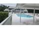 A refreshing community pool is surrounded by lounge chairs and lush greenery at 6618 Pineview Ter # 6618, Bradenton, FL 34203
