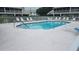 A community pool with a fenced-in area is surrounded by many lounge chairs at 6618 Pineview Ter # 6618, Bradenton, FL 34203