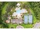 Overhead view of a community pool, playground, and tennis courts nestled in a lush, green setting at 10815 Windswept Garden Way, Tampa, FL 33647