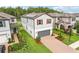 Two-story home with two-car garage, solar panels, red shutters, brick driveway, and beautiful landscaping at 10815 Windswept Garden Way, Tampa, FL 33647