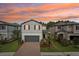 Charming two-story home with a well-manicured lawn, landscaped garden beds and a beautiful sunset at 10815 Windswept Garden Way, Tampa, FL 33647
