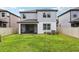 Back exterior view shows siding, screened patio, privacy fence, and green backyard at 10815 Windswept Garden Way, Tampa, FL 33647