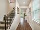 Bright hallway with hardwood floors, staircase, and view of the outdoor space at 10815 Windswept Garden Way, Tampa, FL 33647