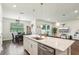 Bright kitchen island open to dining area and living space with sliding door to the outside at 10815 Windswept Garden Way, Tampa, FL 33647