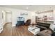 Open-concept living room featuring modern furniture, wood floors, and ample natural light at 10815 Windswept Garden Way, Tampa, FL 33647