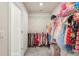 Organized walk-in closet with clothing racks and shelving. Pink toy storage on the floor at 10815 Windswept Garden Way, Tampa, FL 33647