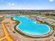 Wide aerial view of a community lagoon with turquoise waters and surrounding development at 10937 Penny Gale Loop, San Antonio, FL 33576
