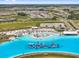 Spectacular aerial view of a large community lagoon with aqua park and beach area at 10937 Penny Gale Loop, San Antonio, FL 33576