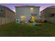 Backyard featuring a well-maintained lawn, recreational equipment and an outdoor seating area at 10937 Penny Gale Loop, San Antonio, FL 33576