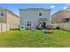 Lush backyard featuring a well-maintained lawn, recreational equipment and an outdoor seating area at 10937 Penny Gale Loop, San Antonio, FL 33576