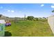 Extensive backyard with lush green grass, play equipment, and privacy fencing at 10937 Penny Gale Loop, San Antonio, FL 33576