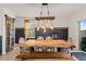 The dining room is equipped with an expansive natural wood table and charming rustic light fixture at 10937 Penny Gale Loop, San Antonio, FL 33576