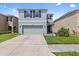 Charming two-story home with a two-car garage, well-manicured lawn, and decorative shutters at 10937 Penny Gale Loop, San Antonio, FL 33576