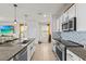 Open kitchen with stainless steel appliances, center island, and an adjacent sitting area with a TV at 10937 Penny Gale Loop, San Antonio, FL 33576
