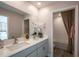 Elegant bathroom featuring double sinks, a large mirror, and a luxurious shower with stylish tile at 12168 Cattleside Dr, Riverview, FL 33579