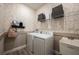 Bright laundry room boasts modern washer and dryer, patterned wallpaper, and shelving with decorative baskets at 12168 Cattleside Dr, Riverview, FL 33579