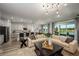 Open-concept living room and kitchen with modern light fixtures, stainless steel appliances, and hardwood flooring at 12168 Cattleside Dr, Riverview, FL 33579