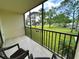 Relaxing screened balcony with outdoor seating and views of the community at 1423 Pine Glen Ln # D2, Tarpon Springs, FL 34688