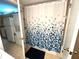 Bathroom with a shower featuring a patterned shower curtain, tiled floors, and gold hardware at 1423 Pine Glen Ln # D2, Tarpon Springs, FL 34688