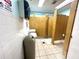 Community bathroom with tile flooring, multiple stalls, and sink at 1423 Pine Glen Ln # D2, Tarpon Springs, FL 34688
