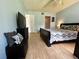 This bedroom offers hardwood floors, a queen bed, a TV, and cool blue paint at 1423 Pine Glen Ln # D2, Tarpon Springs, FL 34688