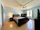 Bright bedroom featuring a ceiling fan, a window offering natural light, and wood-look flooring at 1423 Pine Glen Ln # D2, Tarpon Springs, FL 34688