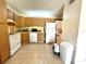 Bright kitchen with wood cabinets, white appliances, and tiled floor, plus in-unit laundry at 1423 Pine Glen Ln # D2, Tarpon Springs, FL 34688