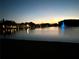 Night view featuring a beautiful pond illuminated with a fountain, reflecting lights on the water for a calming effect at 1423 Pine Glen Ln # D2, Tarpon Springs, FL 34688