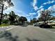 Wide street view of community with mature trees, landscaping, and convenient parking at 1423 Pine Glen Ln # D2, Tarpon Springs, FL 34688