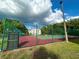 Tennis court with fencing and green surroundings at 1423 Pine Glen Ln # D2, Tarpon Springs, FL 34688