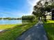 Scenic walking path beside a tranquil lake featuring lush landscaping and a fountain view at 1423 Pine Glen Ln # D2, Tarpon Springs, FL 34688