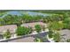 Aerial view of townhomes with garages and driveways surrounded by mature trees and a lake at 2009 River Turia Cir, Riverview, FL 33578