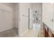 Bathroom with walk-in closet, carpeted floor, and a view to a bedroom with a ceiling fan and natural light at 2009 River Turia Cir, Riverview, FL 33578