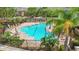 View of community pool with tables, chairs, lounge chairs and lush landscaping at 2009 River Turia Cir, Riverview, FL 33578