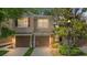 Two story townhome featuring an attached two car garage, manicured lawn and mature landscaping at 2009 River Turia Cir, Riverview, FL 33578