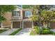Two story townhome featuring an attached two car garage, manicured lawn and mature landscaping at 2009 River Turia Cir, Riverview, FL 33578