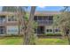 Exterior view of a condominium with a screened in porch surrounded by mature trees and greenery at 2009 River Turia Cir, Riverview, FL 33578