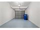 Clean, painted garage interior with sealed flooring and included recycle bin at 2009 River Turia Cir, Riverview, FL 33578