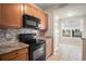 Kitchen with updated black appliances, stylish tile backsplash, and granite countertops at 2009 River Turia Cir, Riverview, FL 33578