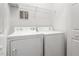 A laundry room features a full-size washer, dryer, and overhead shelving at 2009 River Turia Cir, Riverview, FL 33578