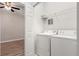 A laundry room features a full-size washer, dryer, and overhead shelving at 2009 River Turia Cir, Riverview, FL 33578