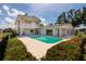 Beautiful backyard featuring a sparkling pool, lush landscaping, and a charming spiral staircase to the second floor at 2063 Illinois Ne Ave, St Petersburg, FL 33703
