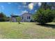 Expansive backyard showcasing a patio deck, lush green lawn, mature trees, and an American Flag at 2132 40Th N Ave, St Petersburg, FL 33714