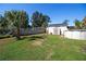 Lush backyard with green grass and mature trees, including a shed, above ground pool, and firepit at 2132 40Th N Ave, St Petersburg, FL 33714