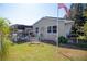 Spacious backyard featuring a patio deck and a swing bench in lush green grass, and an American Flag at 2132 40Th N Ave, St Petersburg, FL 33714