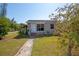 Charming home featuring a well-manicured lawn, walkway, and front door, solar panels and an American flag at 2132 40Th N Ave, St Petersburg, FL 33714